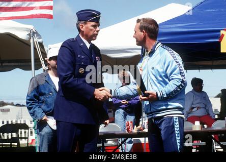 Brigg. GEN. Lance W. Lord, Commander des 30. Weltraumflügels, gratuliert einem Special Olympian bei den Santa Barbara County Special Olympics 1994. Basis: Luftwaffenstützpunkt Vandenberg Bundesstaat: Kalifornien (CA) Land: Vereinigte Staaten von Amerika (USA) Stockfoto