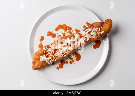 Gönnen Sie sich dazu gebratene Teigstäbchen auf weißem Teller Mekitsa oder Mekika, traditionelles serbisches bulgarisches und Makedoinan-Gericht aus Knete-Teig Stockfoto