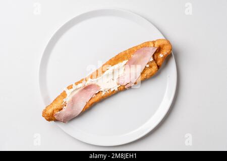 Gönnen Sie sich dazu gebratene Teigstäbchen auf weißem Teller Mekitsa oder Mekika, traditionelles serbisches bulgarisches und Makedoinan-Gericht aus Knete-Teig Stockfoto