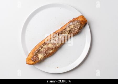 Gönnen Sie sich dazu gebratene Teigstäbchen auf weißem Teller Mekitsa oder Mekika, traditionelles serbisches bulgarisches und Makedoinan-Gericht aus Knete-Teig Stockfoto