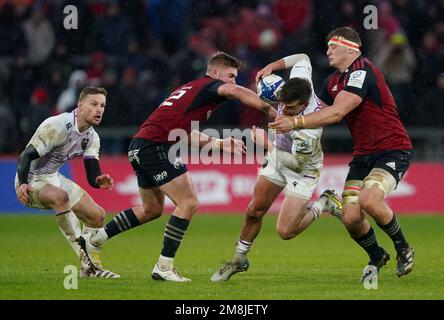 Die Northampton Saints' George Furbank (Zentrum) wird während des Heineken Champions Cup-Spiels im Thomond Park in Limerick, Irland, von Munsters Jack Crowley (links) und Gavin Coombes angegriffen. Foto: Samstag, 14. Januar 2023. Stockfoto