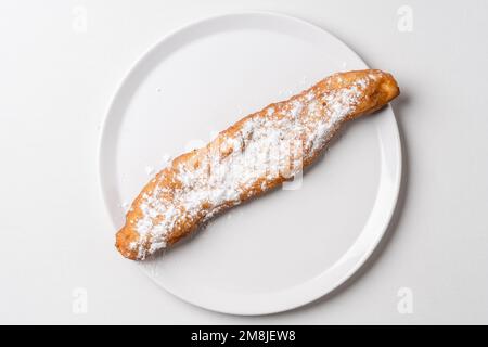 Gönnen Sie sich dazu gebratene Teigstäbchen auf weißem Teller Mekitsa oder Mekika, traditionelles serbisches bulgarisches und Makedoinan-Gericht aus Knete-Teig Stockfoto