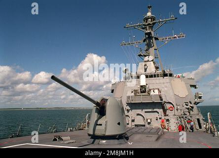 Blick vom Bug auf die Backbrückenseite der Brückenstruktur des gesteuerten Raketenzerstörers USS ARLEIGH BURKE (DDG-51). Im Vordergrund befindet sich die Mark 45-Pistolenhalterung mit einem Kaliber von 54 mm. Hinter der Pistolenhalterung befindet sich der vertikale Mark 41-Abschuss-Raketenwerfer mit 32 Zellen. An der Vorderseite der Brücke befindet sich ein 20mm Mark 15 Close-in Weapon System (CIWS) und auf der rechten Seite der Brücke in einem der STATIONÄREN SPY-ID-Radarantennen-Arrays. Basis: USS Arleigh Burke Country: Atlantik (AOC) Stockfoto