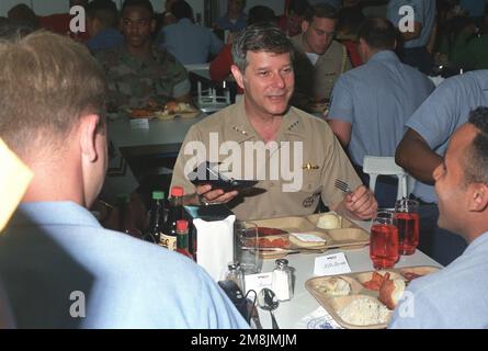 Admiral Jeremy M. Boorda, LEITER der Marineeinsätze (CNO), nimmt Platz und genießt eine Mahlzeit mit einigen Seeleuten an Bord des Flugzeugträgers USS Constellation (CV-64) (genaues Datum unbekannt). Land: Pazifik (POC) Stockfoto