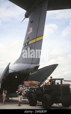 Ein Gabelstapler, der von einem Spezialisten für Lufthäfen gefahren wurde, entladete eine Frachtpalette vom Luftwaffenstützpunkt Charleston, South Carolina, 437. Airlift Wing's C-141 Starlifter am Moi International Airport. Die Hilfsfracht ist für Goma, Zaire, für die Flüchtlinge des ruandischen Bürgerkriegs bestimmt. Betreff Operation/Serie: SUPPORT HOPE Base: Mombasa Country: Kenia (KEN) Stockfoto