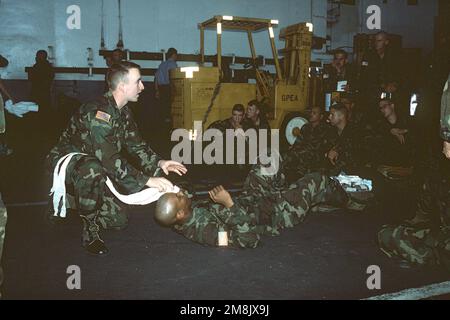 US Army SPECIALIST Fourth Class Justin Enders von Headquarters Company 187, leitet Soldaten mit der 187. Charley Company in Feldmedizin und Evakuierungsverfahren an Bord der USS DWIGHT D. EISENHOWER (CVN 69) während des Transits nach Haiti während der Operation ZUR AUFRECHTERHALTUNG DER DEMOKRATIE. Betrifft Operation/Serie: STÜTZPUNKT DEMOKRATIE: USS Dwight D Eisenhower (CVN 69) Stockfoto
