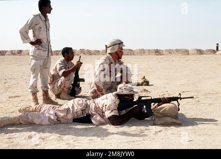 Kuwaitische Soldaten feuern M-16-Gewehre auf die Schusslinie ab, während sie von US-Soldaten der Spezialeinheiten überwacht werden. Die Spezialeinheiten führten eine Feuerausbildung mit den Kuwaits durch und unterrichteten die kuwaitischen Soldaten über den Einsatz und die Pflege der Waffen des Kalibers M-16, MAG58, RPG Nr. 7 und 50. Der Großteil der kuwaitischen Soldaten stammte aus dem 2. Infanterie-Bataillon, 15. Brigade, kommandiert von Major Nori. GENAUES DATUM UNBEKANNT. Betreff Betrieb/Serie: OPERATION VIGILANT WARRIOR Base: Udayri Range Country: Kuwait (KWT) Stockfoto