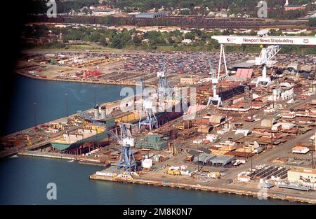 Drydock #12 der Newport News Shipbuilding & Drydock Corporation am James River aus der Vogelperspektive. An der Vorderseite des Docks befindet sich das neue Fahrzeug-Transportschiff GORDON (T-AKR-296) des militärischen Sealift-Kommandos. Im hinteren Teil des Docks befindet sich der modulare Mitschiffsabschnitt des nukleargetriebenen Flugzeugträgers UNITED STATES (CVN-75). Beachten Sie, dass es verschiedene vorgefertigte Abschnitte für den im Hof gestapelten Träger gibt, einschließlich zwei der Aufzüge des Schiffes. Basis: Newport News Bundesstaat: Virginia (VA) Land: Vereinigte Staaten von Amerika (USA) Stockfoto