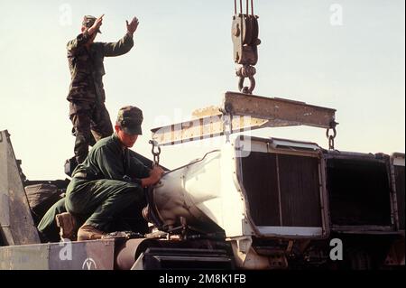 Ein Soldat der 24. Infanteriedivision (mechanisiert) lässt einen Kranführer während DER OPERATION WACHSAMER KRIEGER einen Motor in einen M-1A1 Abrams-Panzer am Fuhrpark in Doha, Kuwait, absenken. Subjekt Operation/Serie: VIGILANT WARRIOR Base: Kuwait City Country: Kuwait (KWT) Stockfoto