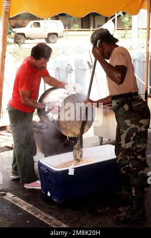 PFC Karen Hobbs, aus Ft. Campbell, KY., arbeitet mit einem Wanderarbeiter zusammen, um das Mehl vom Topf in isolierte Container zu transportieren und in die Lager zu transportieren. Die Kombüse wird von verschiedenen Armeeeinheiten betrieben, um den Migranten warme Mahlzeiten zu servieren. Betreff Betrieb/Serie: SEA SIGNAL V Basis: Guantanamo Bay Country: Kuba (CUB) Stockfoto
