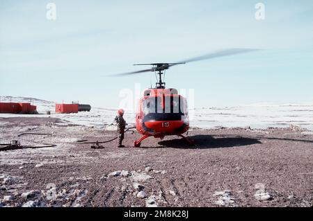 Vorderansicht eines UH-1 Iroquois Huey Helikopters, der am McMurdo Sound betankt wurde, bevor Vizeadmiral Robert J. Spane, Kommandant der Naval Air Force US Pacific Fleet zu einem der Forschungsstandorte flog. Land: Antarktis (ATA) Stockfoto