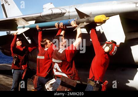 (Von links nach rechts) FLUGZEUGFÜHRER Charles Wylie, PETTY Officers 3. Klasse John Bruner und Jerry Johnson und PETTY Officer 2. Klasse Jerry Tinsley befestigen eine AIM-9 Sidewinder-Trainingskugel am Flügel einer F-14 Tomcat, während der Jäger auf dem Flugdeck der USS KITTY HAWK (CV-63) sitzt. Die KITTY HAWK und ihre an Bord gekommene Fluggesellschaft nehmen an der Multiservice-Übung Teil, da sie vor der Küste operiert. Betreff Betrieb/Serie: TANDEM-SCHUB '95 Land: Vereinigte Staaten von Amerika (USA) Stockfoto