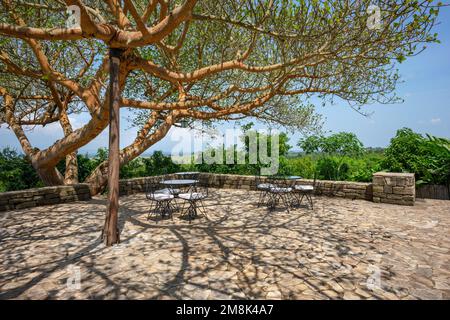 Ein Terrassenbereich im Freien mit Tischen und Sitzgelegenheiten, in der Kyambura Safari Lodge in Rubirizi, West-Uganda. Stockfoto