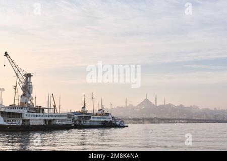 Istanbul, Türkei - Januar 2023: Sonnenaufgang mit Blick auf die Suleymaniye-Moschee und die Skyline der Stadt Golden Horn mit Schiffen am Dock Stockfoto