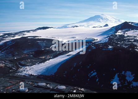 Ein Blick auf einen Teil der McMurdo Station aus Sicht des Observation Hill (Höhe 750 Fuß). Im Hintergrund befindet sich ein schneebedeckter Berggipfel. Staat: McMurdo Sound Country: Antarktis (ATA) Stockfoto