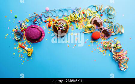 Krapfen, berliner oder Karneval-Donut aus Deutschland mit Puderzucker auf blauem Hintergrund, Kopierraum mit Konfetti und Luftschlangen - Hintergrund für Stockfoto