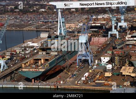 Ein Steuerbord-Viertelblick auf das Fahrzeugfrachtschiff USNS GORDON (T-AKR-296) des Military Sealift Command, das im Trockendock Nr. 12 am Newport News Shipbuilding and Dry Dock Corporation am James River umgebaut wird. Vor dem AKR-296 befindet sich der Mitschiffsabschnitt des nukleargetriebenen Flugzeugträgers Harry Truman (CVN-75). Der Name des Schiffs wurde kürzlich geändert. Verschiedene Abschnitte der modularen Konstruktion des Trägers sind im Hof rechts zu sehen. Basis: Newport News Bundesstaat: Virginia (VA) Land: Vereinigte Staaten von Amerika (USA) Stockfoto