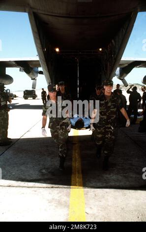 Militärpersonal transportiert einen kubanischen Migrantenpatienten aus einem US Air Force C-130-Flugzeug. Die Migranten werden zur Weiterverarbeitung an die Windseite der Basis gebracht. Betreff Betrieb/Serie: SEESIGNALBASIS: Guantanamo Bay Country: Kuba (CUB) Stockfoto