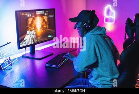 Professionelle eSport-Gamer, die zu Hause in einem Competitive Strategy Video Game bei einem Cyber Games-Turnier spielen. Sprechen Sie über Mikrofone miteinander. Stockfoto