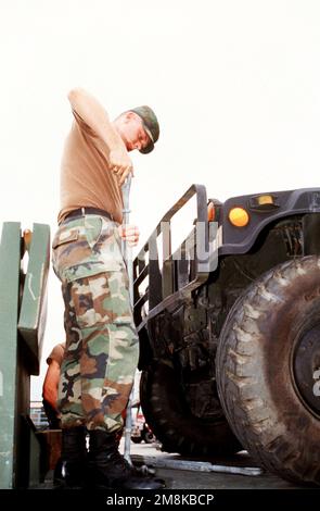 Ein US-Soldat aus der 16. Support Infanterie in Vilseck, Deutschland, arbeitet an der Sicherung eines Mehrzweckfahrzeugs (HMMWV) mit hoher Mobilität auf einem Tieflader zur Vorbereitung auf den Einsatz. SOLDATEN DER US-Armee aus der 3. Infanterie-Division und Soldaten der ukrainischen Armee aus der 24. Motorisierten Rifle-Division werden an der humanitären und friedenserhaltenden Übung in der Nähe von L'viv, Ukraine, teilnehmen. Betreff Operation/Serie: FRIEDENSSCHILD '95 Stützpunkt: Rhein-Main-Luftwaffenstützpunkt Land: Deutschland / Deutschland (DEU) Stockfoto