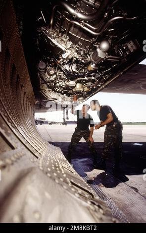 STAFF Sergeant, Kenneth Kisner (links), engagierter Crew Chief, und FLIEGER, Mario Sales (rechts), Crewchef, 9. Bombenstaffel, Dyess Air Force Base, Texas, überprüfen Sie einen der vier F-101/102 Turbinenflugzeuge der B-1B Lancer ihrer Einheit. In 12 Stunden wird dieses Flugzeug „Hellion“ das führende Flugzeug in einer zwei-Schiff-Formation sein, das auf einem Non-Stop-Flug rund um die Welt starten wird, das fünf Betankungen während des Fluges und drei „No-Drop“-Bombenübungen umfassen wird. Nach Abschluss dieses Vorgangs wird der erste (inoffizielle) Weltrekord in dieser Gewichtskategorie aufgestellt. Betreffbetrieb/Se Stockfoto