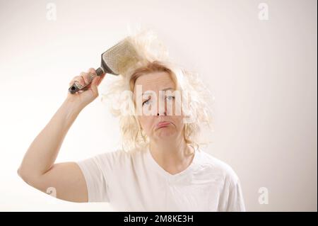 Friseurmedizin Haarrestauration beschädigte Haare mit gespaltenen Enden übergetrocknet verzogene Erwachsene Frau blond färben weiß beschädigte traurige Frau mit geschwollenem C Stockfoto