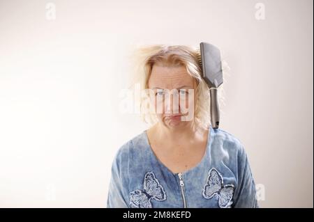 Friseurmedizin Haarrestauration beschädigte Haare mit gespaltenen Enden übergetrocknet verzogene Erwachsene Frau blond färben weiß beschädigte traurige Frau mit geschwollenem C Stockfoto