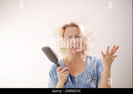 Friseurmedizin Haarrestauration beschädigte Haare mit gespaltenen Enden übergetrocknet verzogene Erwachsene Frau blond färben weiß beschädigte traurige Frau mit geschwollenem C Stockfoto