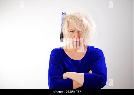 Friseurmedizin Haarrestauration beschädigte Haare mit gespaltenen Enden übergetrocknet verzogene Erwachsene Frau blond färben weiß beschädigte traurige Frau mit geschwollenem C Stockfoto
