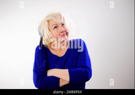 Friseurmedizin Haarrestauration beschädigte Haare mit gespaltenen Enden übergetrocknet verzogene Erwachsene Frau blond färben weiß beschädigte traurige Frau mit geschwollenem C Stockfoto