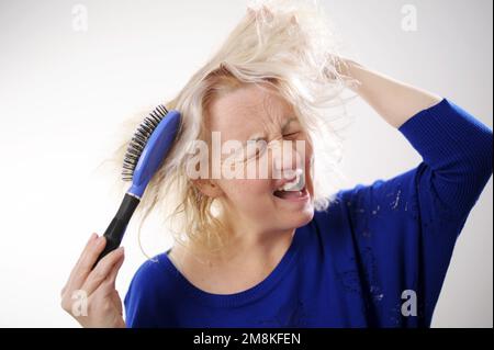 Friseurmedizin Haarrestauration beschädigte Haare mit gespaltenen Enden übergetrocknet verzogene Erwachsene Frau blond färben weiß beschädigte traurige Frau mit geschwollenem C Stockfoto