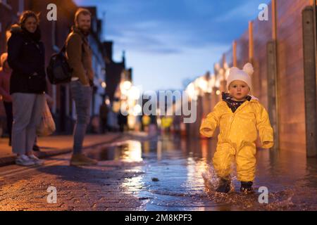 Bewdley, Großbritannien. 14. Januar 2023. Da das Wasser des geschwollenen Flusses Severn auf gefährlich hohen Ebenen auf der anderen Seite der Barrieren fließt, sind die Bewdley-Leute unglaublich dankbar, dass die Hochwasserschutzvorrichtungen ihnen die Möglichkeit geben, ihr Leben normal weiterzuführen, Sicherheit auf ihrer Seite... Sogar Zeit für ein Spritzen in Ihren Gummistiefeln! Kredit: Lee Hudson/Alamy Live News Stockfoto