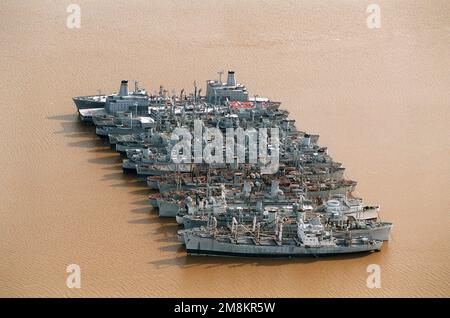 Luftaufnahme von Einheit 7 der Reserve-Flotte in der Nähe von Fort Eustis. Von unten nach oben, unidentifizierte AK, Santa Cruz Vulcan (AR-5), Redstone (T-AGM-20), 2 unidentifizierte APs, GEN. N.M. Walter (T-AP-125), Baracke Schiff GEN. Wm. O. Darby (IX-510), Waccamaw (T-AO-109), Canisteo (T-AO-99), Caloosahatchee (T-AO-98), Mississinewa (T-AO-144), Pawcatuck (T-AO-108), Truckee (T-AO-147), Neosho (T-AO-143) und Flottenöler USNS Benjamin Isherwood (T-AO-191) und Henry Eckford (T-AO-192). Diese beiden Öler waren beide unvollständig liegengeblieben. Basis: James River Bundesstaat: Virginia (VA) Land: Vereinigte Staaten von Amerika Stockfoto