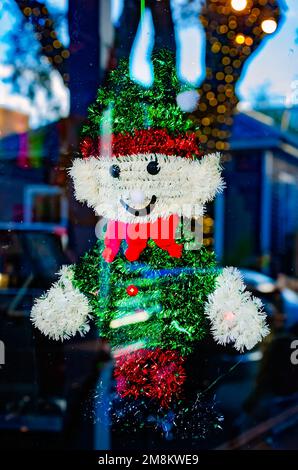 Am 28. Dezember 2022 in Ocean Springs, Mississippi, hängt ein aus Lametta gefertigtes Schneemannelf-Weihnachtsschmuck aus den 60er Jahren in einem Fenster an der Washington Avenue. Stockfoto