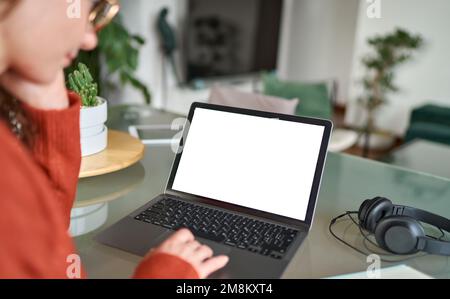Über die Schulter sehen Sie E-learning-Inhalte von Frauen, die mit einem Notebook auf einen Bildschirm schauen. Stockfoto