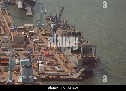 Viertelansicht des Transportschiffs USNS GORDON (T-AKR-296) des Militärs Sealift Command aus der Luft, das am Liegeplatz 2 am Newport News Shipbuilding und an der Drydock Corporation Shipyard umgebaut wird. Der Bug des Flugzeugträgers HARRY S. TRUMAN (CVN-75) im Vordergrund befindet sich im Trockendock 12 im Bau. Im Hintergrund befindet sich die USNS GILLILAND (T-AKR-298), die am Liegeplatz 1 umgebaut wird. Basis: James River Bundesstaat: Virginia (VA) Land: Vereinigte Staaten von Amerika (USA) Stockfoto