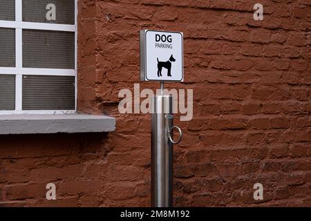 Nahaufnahme eines Hundeparkschilds, draußen. Ein Ort, an dem man den Hund fesseln kann, und der vor Geschäften und Restaurants, in denen Haustiere nicht erlaubt sind, auf Besitzer wartet. Stockfoto