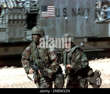 Zwei US-Marines kandidieren um Positionen, nachdem sie während der RIMPAC '96 in der Pacific Missile Range Facility, Barking Sands, Kauai, Hawaii, von der USS ESSEX (LPH 9) (nicht abgebildet) ein Landing Craft Air Polstated (LCAC) verlassen haben. Betreff Betrieb/Serie: RIMPAC '96 Basis: Kauai Bundesstaat: Hawaii (HI) Land: Vereinigte Staaten von Amerika (USA) Stockfoto