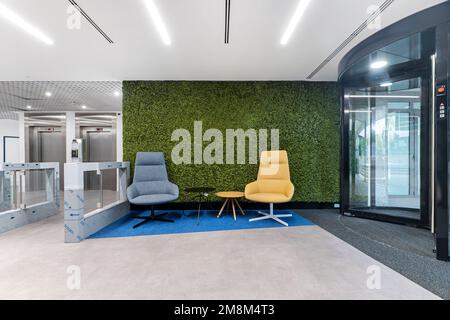 Lobby eines Bürogebäudes mit runden Tischen und Sesseln für Besucher Stockfoto