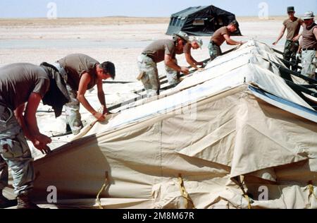 Mitglieder der 823. Rotpferd-Staffel aus Hurlbert Field Florida und der 49. Materialinstandhaltungsgruppe aus dem Luftwaffenstützpunkt Holloman New Mexico bauen eines von 500 Zelten, in denen mehr als 4.000 Personen untergebracht werden, um die Umsiedlung der Operation Southern Watch zu unterstützen. Betreff Operation/Serie: Wüstenstützpunkt: Prince Sultan Luftwaffenstützpunkt Land: Saudi-Arabien (Sau) Stockfoto