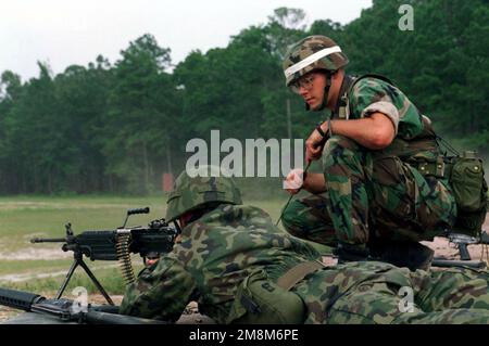 Als US-Marine-Ausbilder vom 2. Bataillon beobachtet 6. Marines einen polnischen Soldaten, wie er sich während der Operation OSPREY 96 auf den Abschuss einer automatischen Waffe des 5,56mm M249. Teams (SAW) auf Reichweite L-5 vorbereitet, während der Live-Feuerübung des Situationstrainings 3 (STX-3) in Camp Lejeune, NC. 6. 3 Marines, ein US-Marine-Ausbilder des 2. Bataillons, beobachtet einen Soldaten der polnischen Armee, wie er während der Operation OSPREY in Camp Lejeune, NC, eine automatische Waffe (SAW) der 5,56mm M249 3. Einheit auf Reichweite L-5 abfeuert Stockfoto