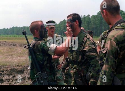 US-Marines vom 2. Bataillon, 6. Marines, unterstützen slowakische Truppen beim Aufbringen ihrer Tarnfarbe während der Lageübung-1, Konvoi-Operationen, GENOSSENSCHAFT OSPREY 96. Cooperative Osprey '96 ist eine vom US-amerikanischen Atlantikkommando geförderte Übung, die im August 1996 von Marine Forces Atlantic im Camp Lejeune, North Carolina, durchgeführt wird. Cooperative Osprey wird im Rahmen des Programms „Partnerschaft für den Frieden“ Interoperabilitätsschulungen für Friedenssicherungseinsätze und humanitäre Einsätze nach NATO/IFOR-Standards anbieten, wobei der Schwerpunkt auf individuellen und kollektiven Fähigkeiten liegt. Unterg Stockfoto