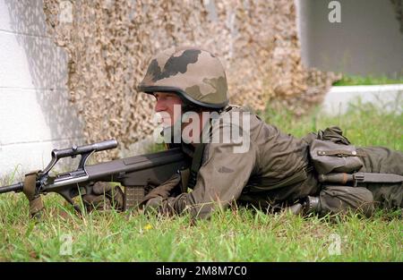 Ein österreichischer Soldat, bewaffnet mit einem Steyr AUG Gewehr, bietet Sicherheit während der letzten Trainingsübung 2, COOPERATIVE OSPREY 96. Die letzte Trainingsübung 2 besteht aus militärischen Einsätzen in städtischem Gelände, Sicherheits- und zivilen Unruhen in Camp LeJeune, North Carolina. Cooperative Osprey ist eine vom US-amerikanischen Atlantikkommando gesponserte Übung, die von Marine Forces Atlantic in Camp Lejeune, North Carolina, durchgeführt wird. Cooperative Osprey wird im Rahmen des Programms „Partnerschaft für den Frieden“ Interoperabilitätsschulungen in Friedenssicherungseinsätzen und humanitären Maßnahmen gemäß NATO/IFOR-Standards mit durchführen Stockfoto