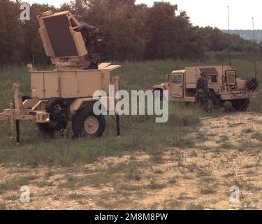 Während eines simulierten taktischen Szenarios wird SPC Bryan A. Cook, HHB 1. der 44. Air Defense Artillery (ADA), 4. Infanterie Division, gezeigt, wie sie das Radar auf der Feldausrüstung des Forward Area Air Defense Ground Base Sensor (FAAD GBS) anhebt. PFC John P. Peart, ebenfalls von HHB 1-44 ADA, 4. Infantry Division, wird an der Generatorsteuerung angezeigt. Ein Mehrzweckfahrzeug mit Mobilitätssystem (HMMWV) befindet sich im Hintergrund. Basis: Fort Hood Bundesstaat: Texas (TX) Land: Vereinigte Staaten von Amerika (USA) Stockfoto