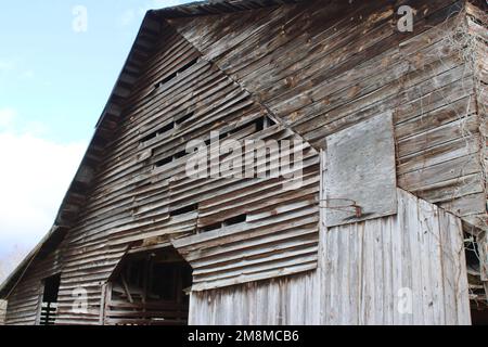 Verwitterte alte Stallwand mit Basketballkorb Stockfoto