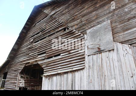 Verwitterte alte Stallwand mit Basketballkorb Stockfoto