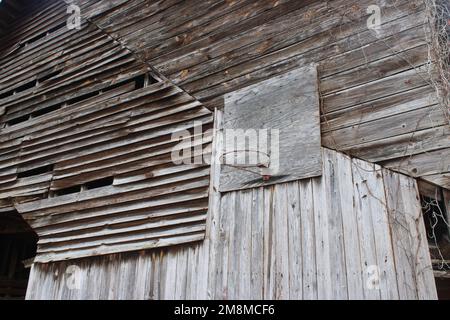 Verwitterte alte Stallwand mit Basketballkorb Stockfoto