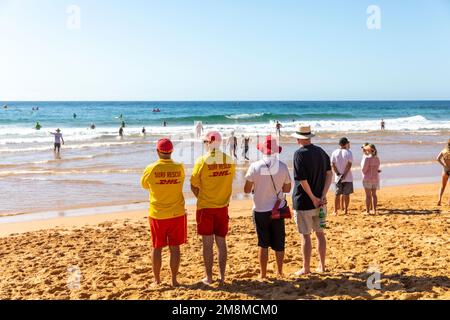 Bilgola Beach Ocean Swim Surf Race 2023. Januar beobachten Zuschauer, einschließlich Surf Rescue Freiwillige Rettungsschwimmer, die Schwimmer im Ozean, Australien Stockfoto