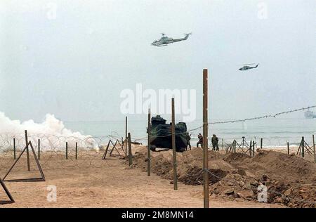 970628-M-9816M-013. [Complete] Scene Caption: Während Marine Bell AH-1W Super Cobras Feuerunterstützung bieten, macht Photographer's Mate First Class (PH1) Batiz (rechts vom Amhibious Assault Vehicle (AAV)), von Combat Camera, Fleet Imaging Command Pacific, ein Foto während des Amphibienangriffs auf Red Beach, Übung KERNEL BLITZ '97. KERNEL BLITZ ist eine zweijährliche Flottenübungsübung (FLEETEX) des Oberbefehlshabers der Pazifikflotte (CINCPAC) mit Schwerpunkt auf operativer/taktischer Ausbildung des Oberbefehlshabers der Third Fleet (C3F)/ I Marine Expeditionary Forces (MEF) und des Oberbefehlshabers der Amphibienflotte der Gruppe 3 (CPG-3)/ 1. Marine Divisi Stockfoto