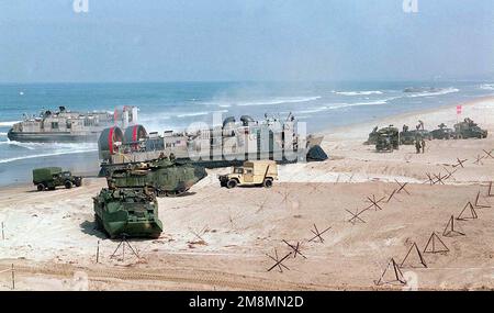 970628-M-9816M-030. [Complete] Scene Caption: Landing Craft, Air Polstated (LCAC) Entlade während des Amphibienangriffs eine dritte Aktivitätswelle am Red Beach im Rahmen des TRAININGSKERNELS BLITZ 97 im Camp Pendleton, Kalifornien. Im Vordergrund beginnt ein Amphibienfahrzeug (AAV-7A1), den Strand zu verlassen, während M998 mittelgroße Fahrzeuge mit hoher Mobilität (HMMWV) inszeniert werden (rechter Hintergrund). KERNEL BLITZ ist eine zweijährliche Flottenübungsübung (FLEETEX) des Oberbefehlshabers Pacific (CINCPAC) mit Schwerpunkt auf operativer/taktischer Ausbildung des Oberbefehlshabers der Third Fleet (C3F)/ i Marine Expeditionary Forces (MEF). Stockfoto
